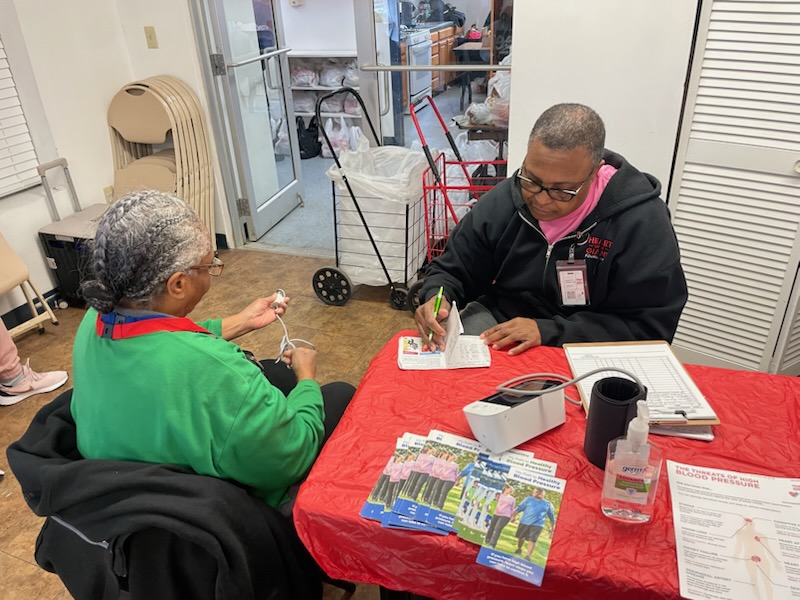 A community health worker on a porch step in Mattapan.