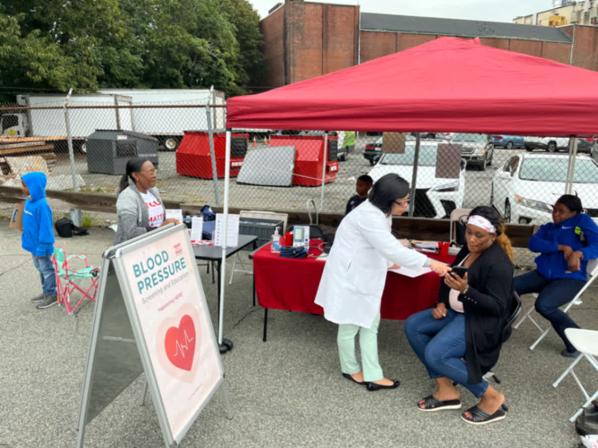 A Heart of a Giant screening under the red canopy at a Mattapan site.
