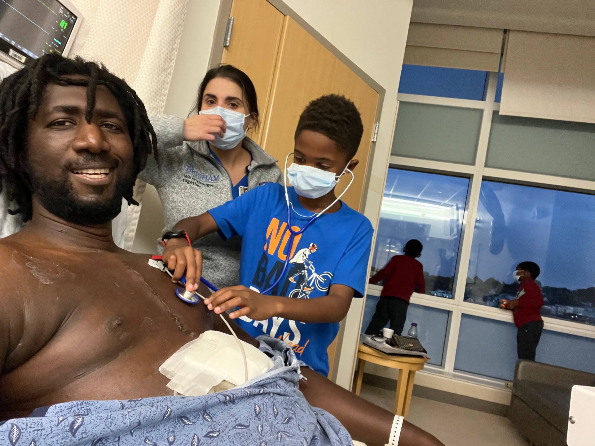 One of Bouba's sons listening to his new heart through a stethoscope.