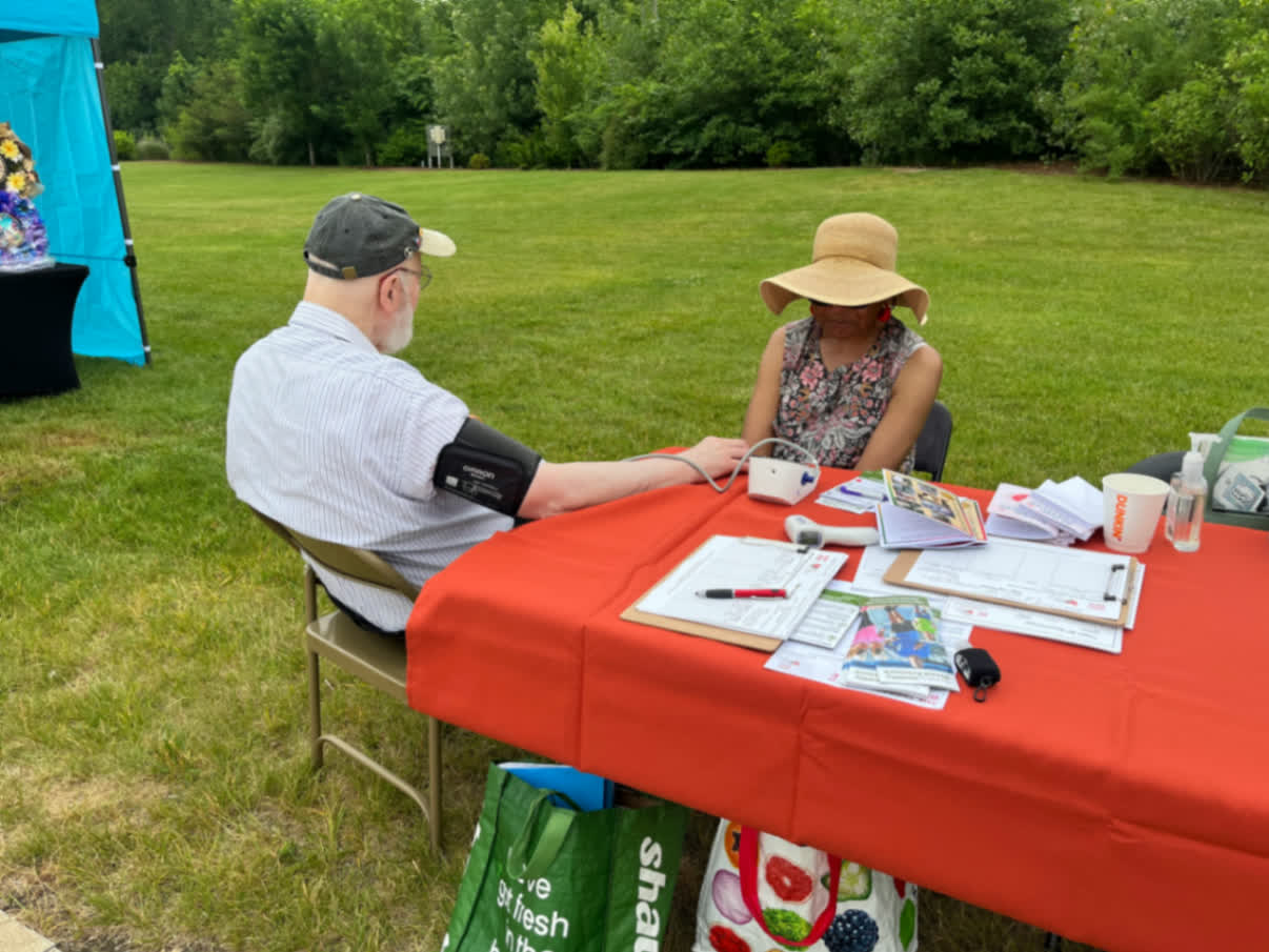 Outdoor screening table with a participant mid-visit.